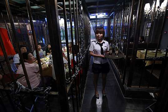 Restaurante serve clientes atrás das grades na China (Foto: Reuters)
