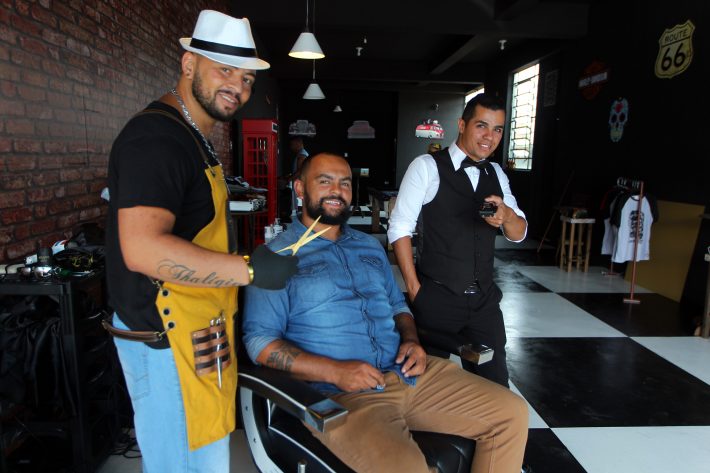 Elton dos Santos (sentado) abriu barbearia que tem cerveja, bilhar e fliperama 